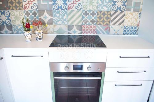 a kitchen with white cabinets and a stove at Aleari Villa Fanusa in Fanusa