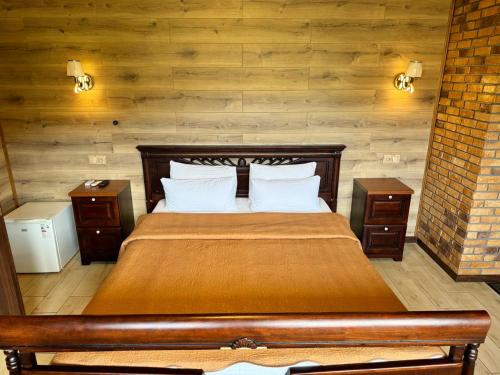 a bedroom with a large bed with two night stands at Готель Довбуш in Yaremche