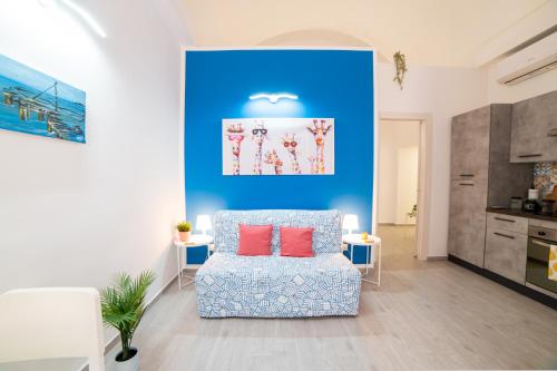 a living room with a chair and a blue wall at Napoli Centro Casa Vacanza in Naples