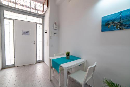 a white table and chairs in a room with a door at Napoli Centro Casa Vacanza in Naples