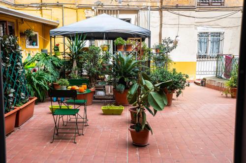 a patio with a table and chairs and plants at Napoli Centro Casa Vacanza in Naples