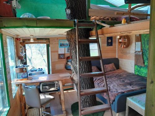 a bedroom with a bunk bed and a desk in a tree at Tree house Ramona & Fairytale wooden house by Ljubljana in Grosuplje