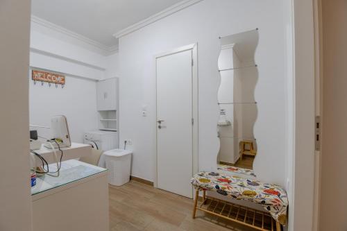 una cocina blanca con un banco en una habitación en Kallithea Gardenspot en Atenas