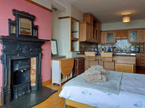 a room with a fireplace and a table with towels on it at High View Studio with terrace & sea views in Barmouth