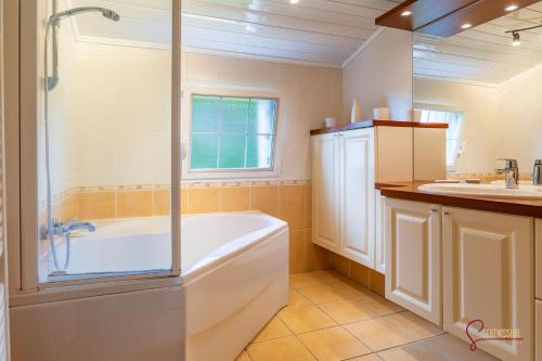 een badkamer met een bad en een wastafel bij La maison de la petite lande in Saint-Jean-du-Doigt