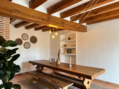 a dining room with a wooden table and benches at Le Clos de la Michaudiere in Cellettes