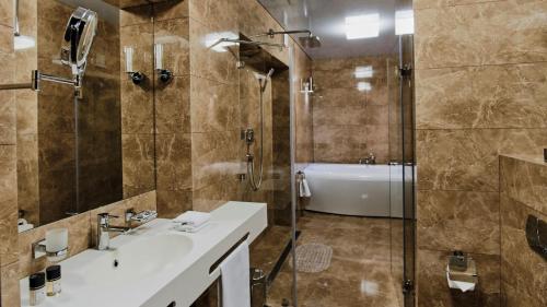 a bathroom with a shower and a sink and a tub at Vozdvyzhensky Boutique Hotel in Kyiv