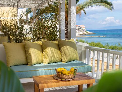 Avlákia的住宿－Aegean Stories pelagos suites，门廊上的沙发,桌子上放着一碗水果