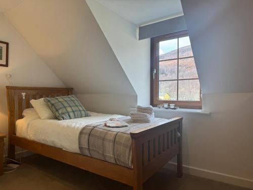 een slaapkamer met een bed en een raam bij Rosemount Bothy - Highland Cottage in Garve
