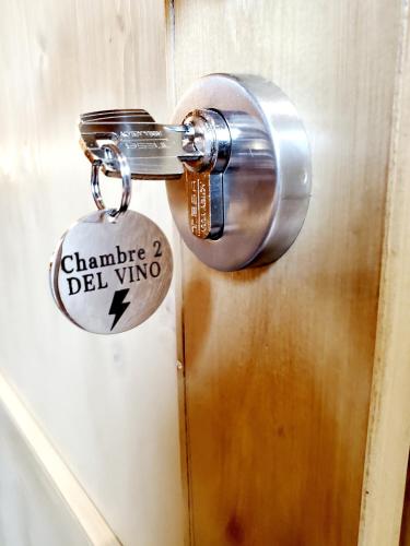Una cerradura en una puerta con una etiqueta. en DEL VINO bar à vin & guitares, en Orchamps-Vennes