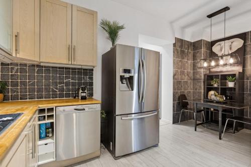 a kitchen with a stainless steel refrigerator and a table at Cozy room in central Oslo Grunerløkka in Oslo