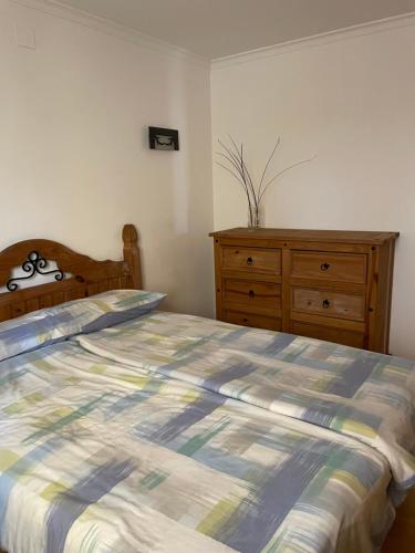 a bedroom with a bed and a wooden dresser at Cumbre Del Sol Segrelles 11 in Cumbre del Sol