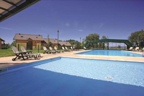 une grande piscine avec des chaises et une table dans l'établissement Lugrin proche du Lac et Montagne, à Lugrin