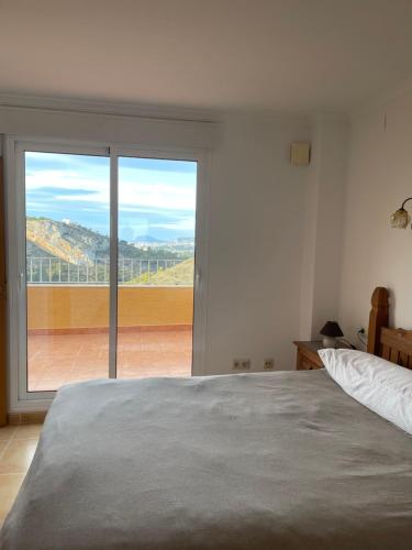 a bedroom with a bed and a large window at Cumbre Del Sol Segrelles 11 in Cumbre del Sol