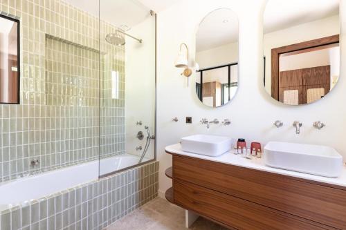 ein Badezimmer mit zwei Waschbecken, einer Badewanne und einem Spiegel in der Unterkunft Villa Toscane in Saint-Tropez