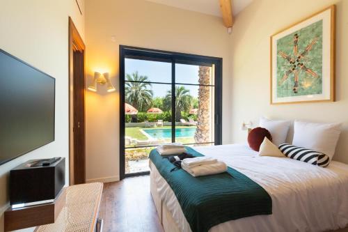 Schlafzimmer mit einem Bett und Poolblick in der Unterkunft Villa Toscane in Saint-Tropez