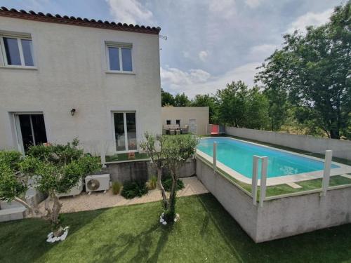 une maison avec une piscine devant une maison dans l'établissement Villa sans vis-à-vis avec vue et piscine située entre Nîmes et Montpellier, à 20 minutes des plages, à Aigues-Vives