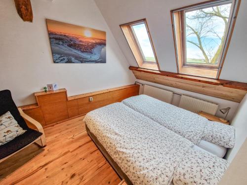 a small bedroom with a bed and two windows at De Gelukskever in Hindeloopen