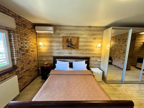 a bedroom with a large bed and a brick wall at Готель Довбуш in Yaremche