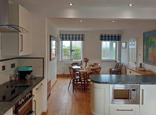 uma cozinha e sala de jantar com uma mesa em Garreg Wen - White Stone, family holiday home em Barmouth