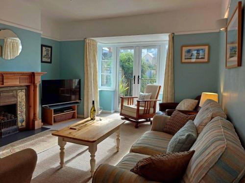 a living room with a couch and a table at Garreg Wen - White Stone, family holiday home in Barmouth