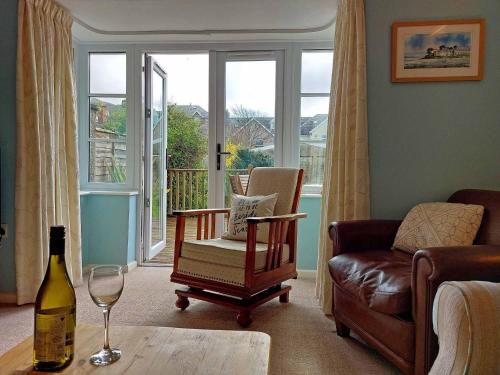 a living room with a chair and a wine glass at Garreg Wen - White Stone, family holiday home in Barmouth