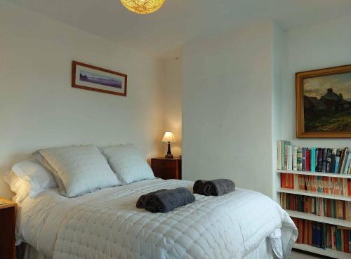 a bedroom with a bed with two towels on it at Garreg Wen - White Stone, family holiday home in Barmouth
