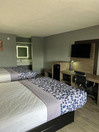 KennettにあるEcono lodge Kennettのベッド、デスク、テレビが備わるホテルルームです。