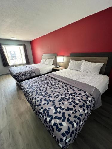 Kennett的住宿－Econo lodge Kennett，酒店客房设有两张床和红色的墙壁。