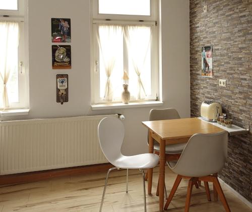 a dining room with a wooden table and chairs at Ferienwohnung im Logierhaus Villa Ihler in Luisenthal