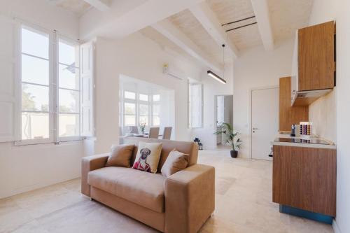 - un salon avec un canapé dans une pièce dotée de fenêtres dans l'établissement Rare Seaview Condo in Valletta 2, à La Valette