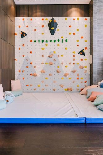 a large bed in a room with a climbing wall at AlpenGold Hotel Davos in Davos