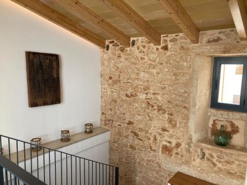 a room with a stone wall and a staircase at Can Roig in Ses Salines