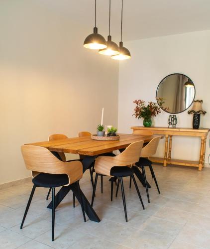 a dining room table with chairs and a mirror at Alba Spacious Maisonette in Corfu