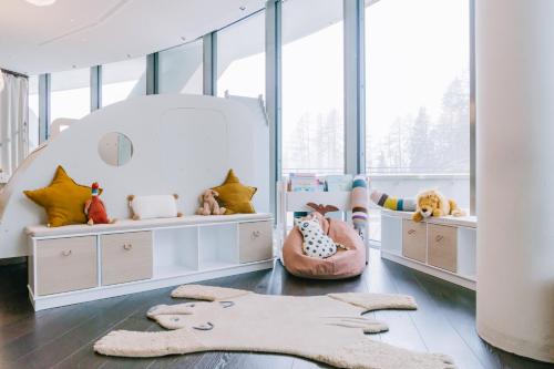 a childs room with two beds and a large window at AlpenGold Hotel Davos in Davos