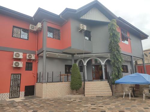 una casa con un ombrello blu davanti di HOTEL APPART B4U - BE FOR YOU a Yaoundé