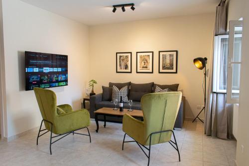 a living room with a couch and a table and chairs at Alba Spacious Maisonette in Corfu