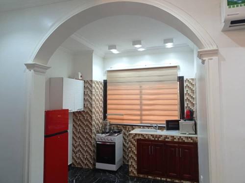 una cucina con frigorifero rosso e piano cottura di HOTEL APPART B4U - BE FOR YOU a Yaoundé
