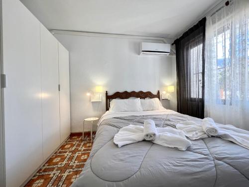 Un dormitorio con una cama grande con toallas. en Apartamento en el Albir - Inmodream Calpe, en Albir