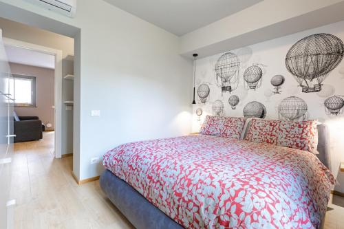 1 dormitorio con cama y pared con globos de aire caliente en La Casa Nelle Aie - App. Nebbiolo -Box Auto & WiFi, en La Morra