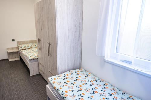 a room with two beds and a window and a bed at Penzion Fann in Humpolec