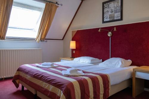 une chambre d'hôtel avec un lit et des serviettes. dans l'établissement Hotel De Torenhoeve, à Burgh-Haamstede