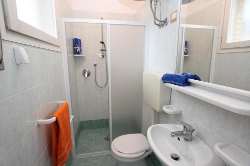 ein Bad mit einer Dusche, einem WC und einem Waschbecken in der Unterkunft Tamerici in Bibione