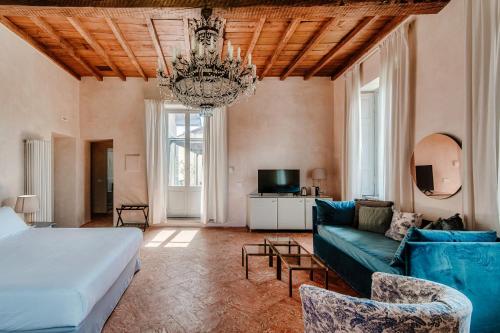 a bedroom with a bed and a couch and a chandelier at Dandelion Como Suites & Park in Villa Guardia