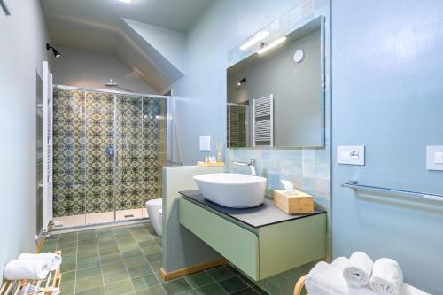 La salle de bains est pourvue d'un lavabo et d'une douche. dans l'établissement La Casa Nelle Aie - Appartamento Dolcetto - Private Parking - Free Wifi & AC, à La Morra