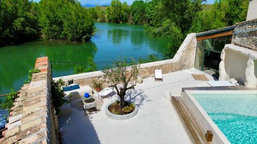 - une vue aérienne sur une piscine et un lac dans l'établissement Les Terrasses de Bélarga - Maison d'hôtes - Piscine et Jacuzzi, à Bélarga