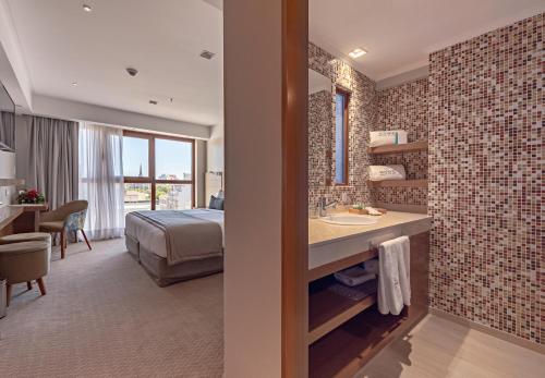 a hotel room with a bed and a bathroom with a sink at HOTEL KONKE MAR DEL PLATA in Mar del Plata