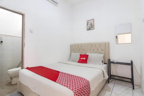 Un dormitorio con una cama con almohadas rojas. en OYO 93720' 3D Residence Near Univ Tarumanegara en Yakarta