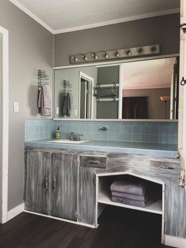 a bathroom with a sink and a mirror at Deer Hollow Cottage at Tradewinds in Eureka Springs