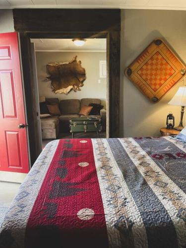 a bedroom with a bed and a living room with a couch at Deer Hollow Cottage at Tradewinds in Eureka Springs